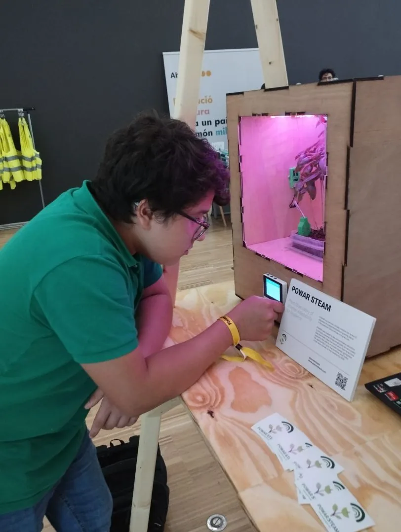 Una visitant interactuant amb el prototip de POWAR STEAM a l'estand de la fira