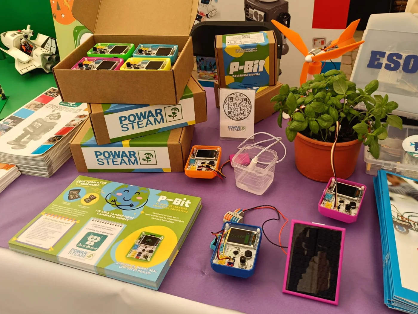 Taula amb el kit P-Bit: caixes, quaderns, P-Bit de colors, plantes i un panell solar