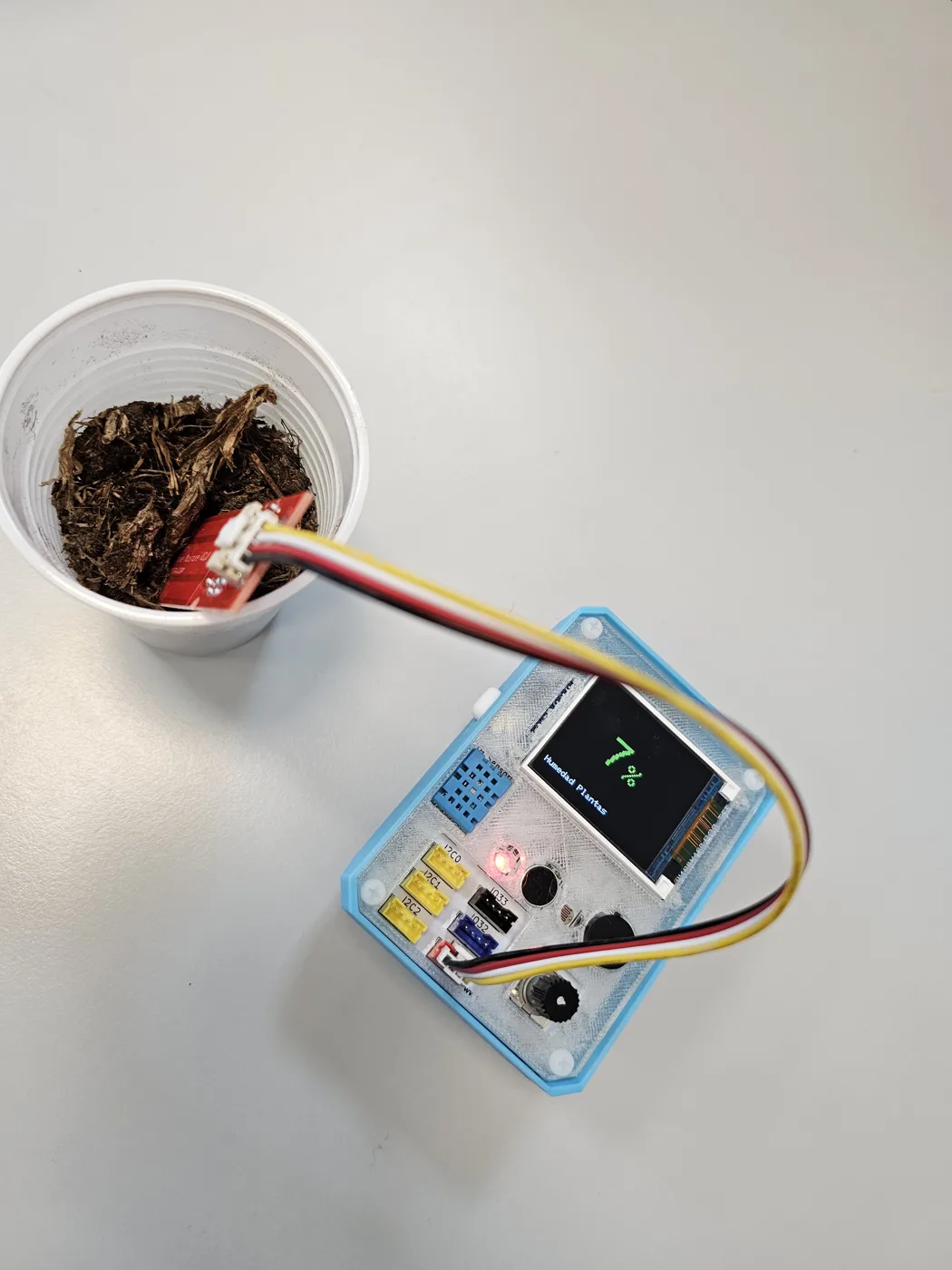 P-Bit v3 amb el sensor d'humitat del sòl en un got amb terra