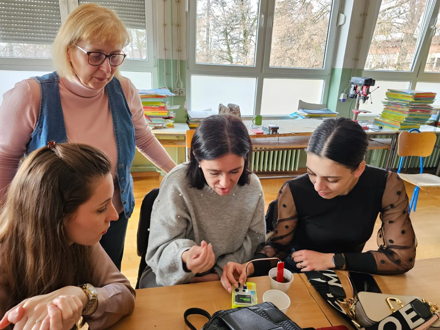 Three teachers take readings with the P-Bit during a training session