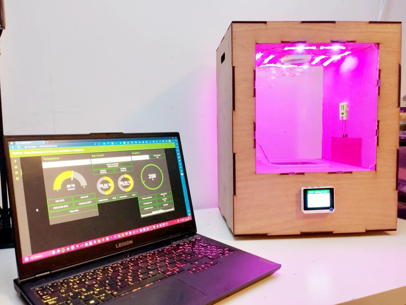 Third POWAR prototype with grow lights and the platform dashboard on a laptop